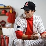 Baseball player blowing bubble with gum in locker room