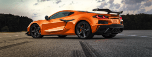 A orange sports car is parked on the street.